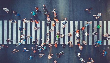 Aerial. People crowd motion through the pedestrian crosswalk. Top view from drone. Toned image.